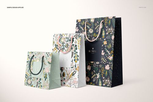 Set of three floral paper bags with different sizes and pastel colors, arranged side by side in a PSD mockup scene.