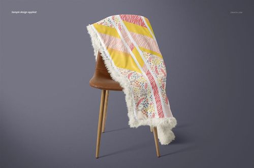 Mockup of a sherpa baby blanket featuring yellow, pink, and multicolor designs, displayed on a mid-century chair.