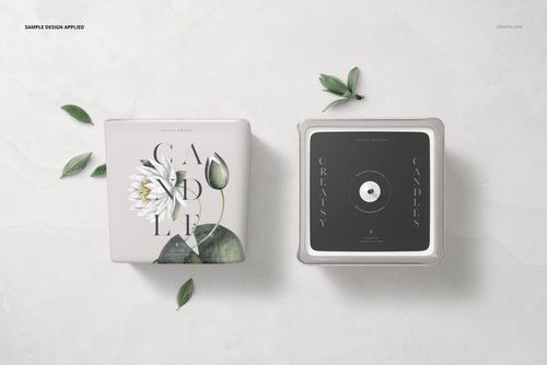 Square candle mockup featuring two candles with paper labels, viewed from front and top on a light marble surface.