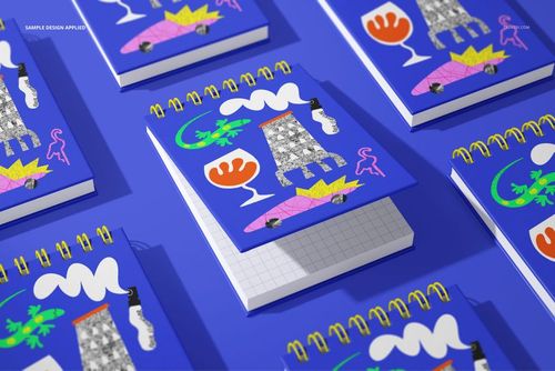 Multiple spiral ring flip top notebook mockups with vibrant graphic designs and yellow rings, top view on blue background.