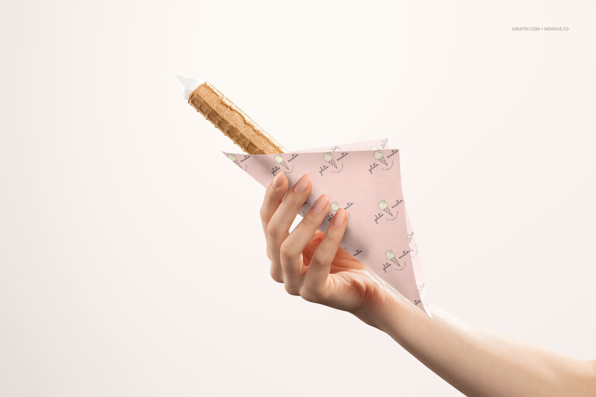 Ice cream cone in whimsical pink food safe paper held by a hand, shown in a realistic PSD mockup scene.