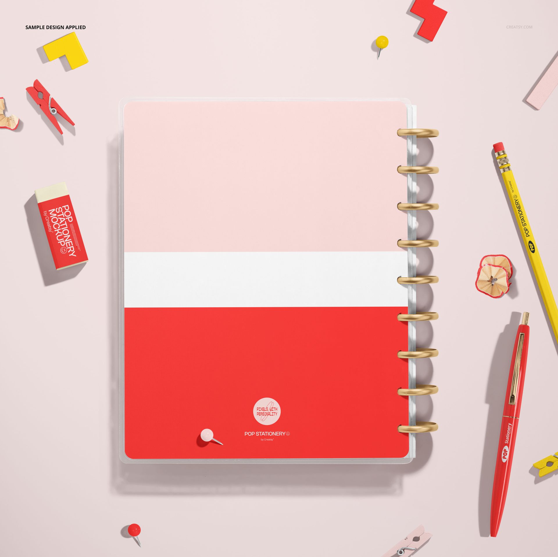 Spiral planner mockup shown from above, featuring a bold pink, white, and red cover on a light background.