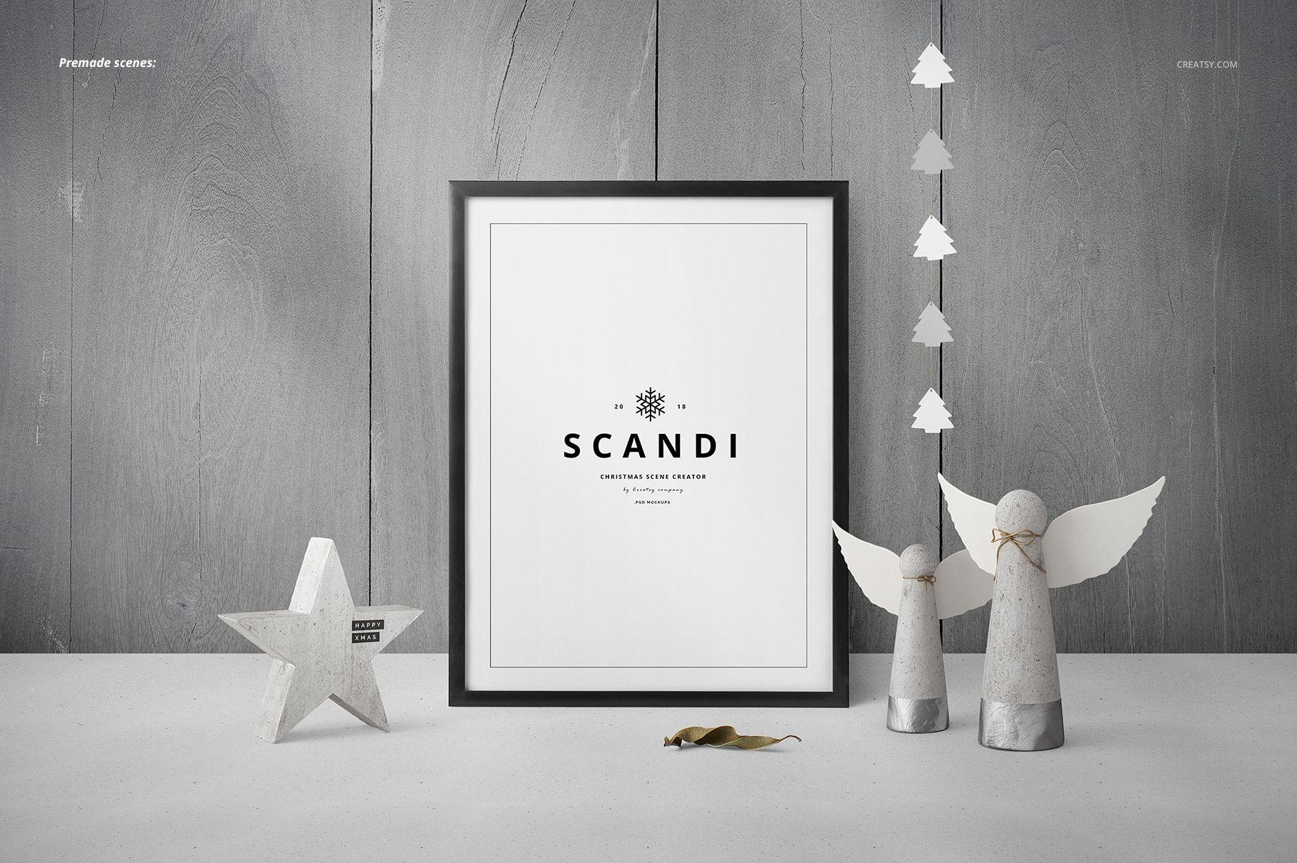 Framed poster mockup with minimalist Christmas decor, including wooden angels, a star, and tree garland on a gray wood background.