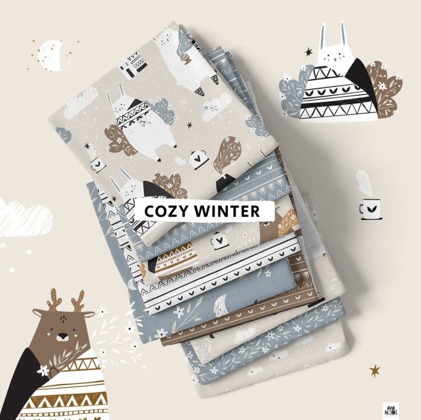 Fabric stack mockup showing folded patterned fabrics in muted blue, beige, and brown with winter animal illustrations and a text overlay.