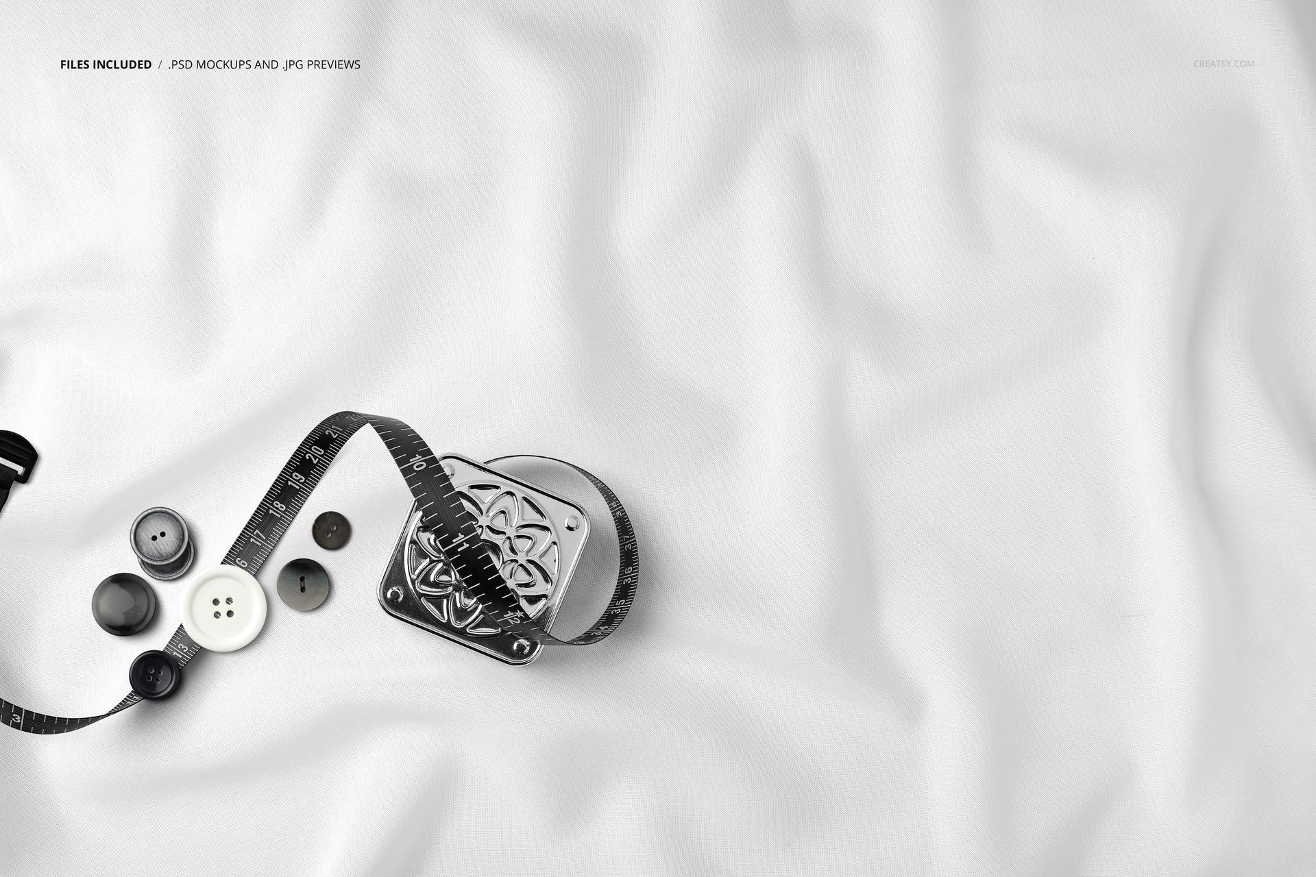 Top view close-up of white fabric with measuring tape, assorted buttons, and subtle folds, shown in a mockup scene.