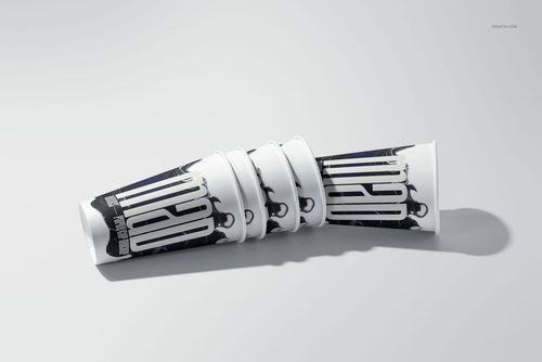PSD mockup of paper cups with modern monochrome patterns, displayed in a horizontal arrangement on a plain surface.