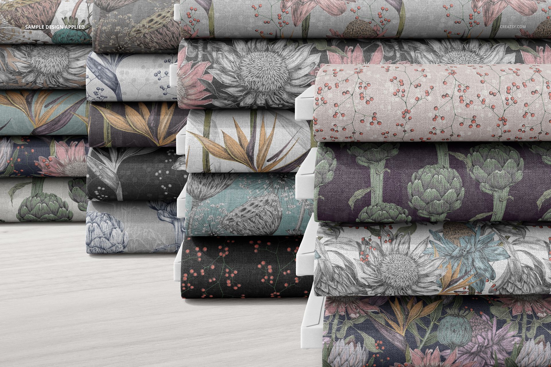 Front view of several fabric bolts with intricate flower and leaf motifs, presented as a PSD mockup on a pale background.