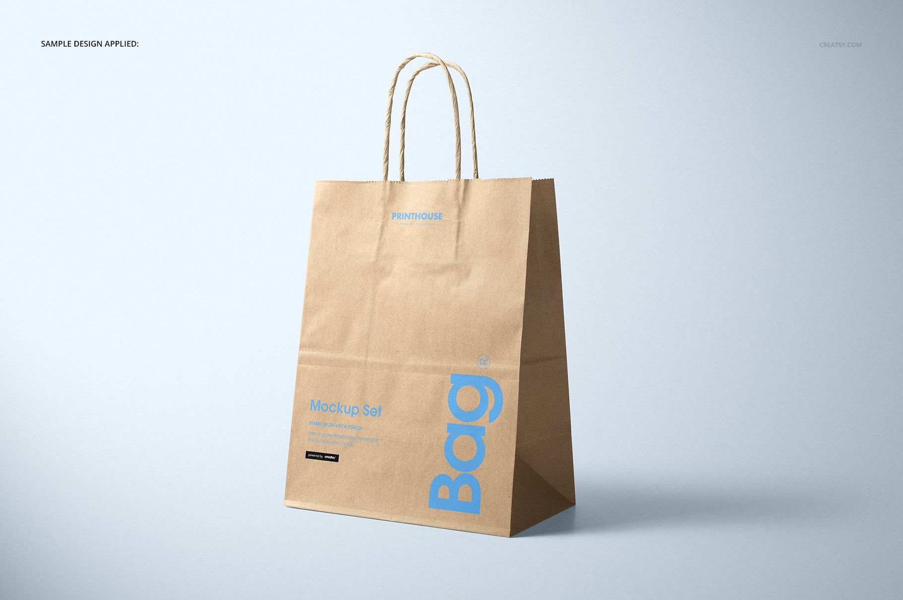 Natural kraft paper shopping bag mockup standing upright, showing blue printed text and sturdy paper handles.