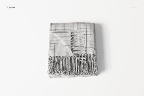 Folded fringe blanket with wrapped corner, featuring a grid pattern and visible tassels, shown from above on a white surface.