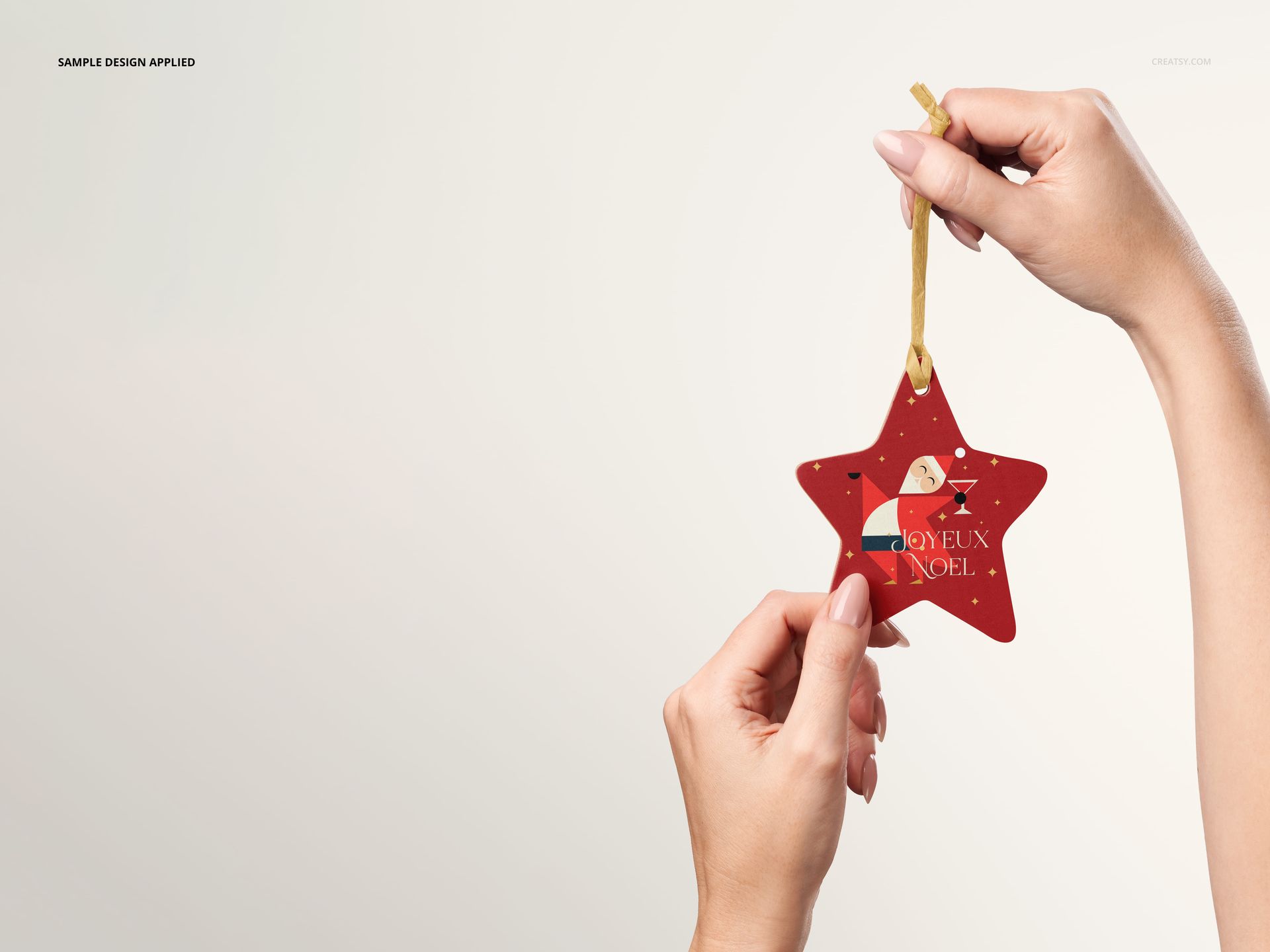Mockup of a star-shaped wooden ornament with holiday graphics, held by hands against a neutral background.