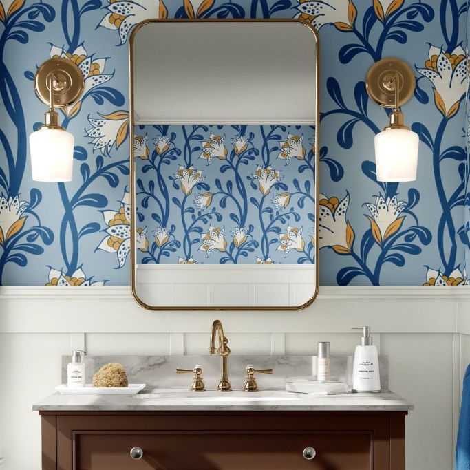 Bathroom mockup featuring a marble countertop vanity, brass fixtures, and a large mirror with floral blue wallpaper.