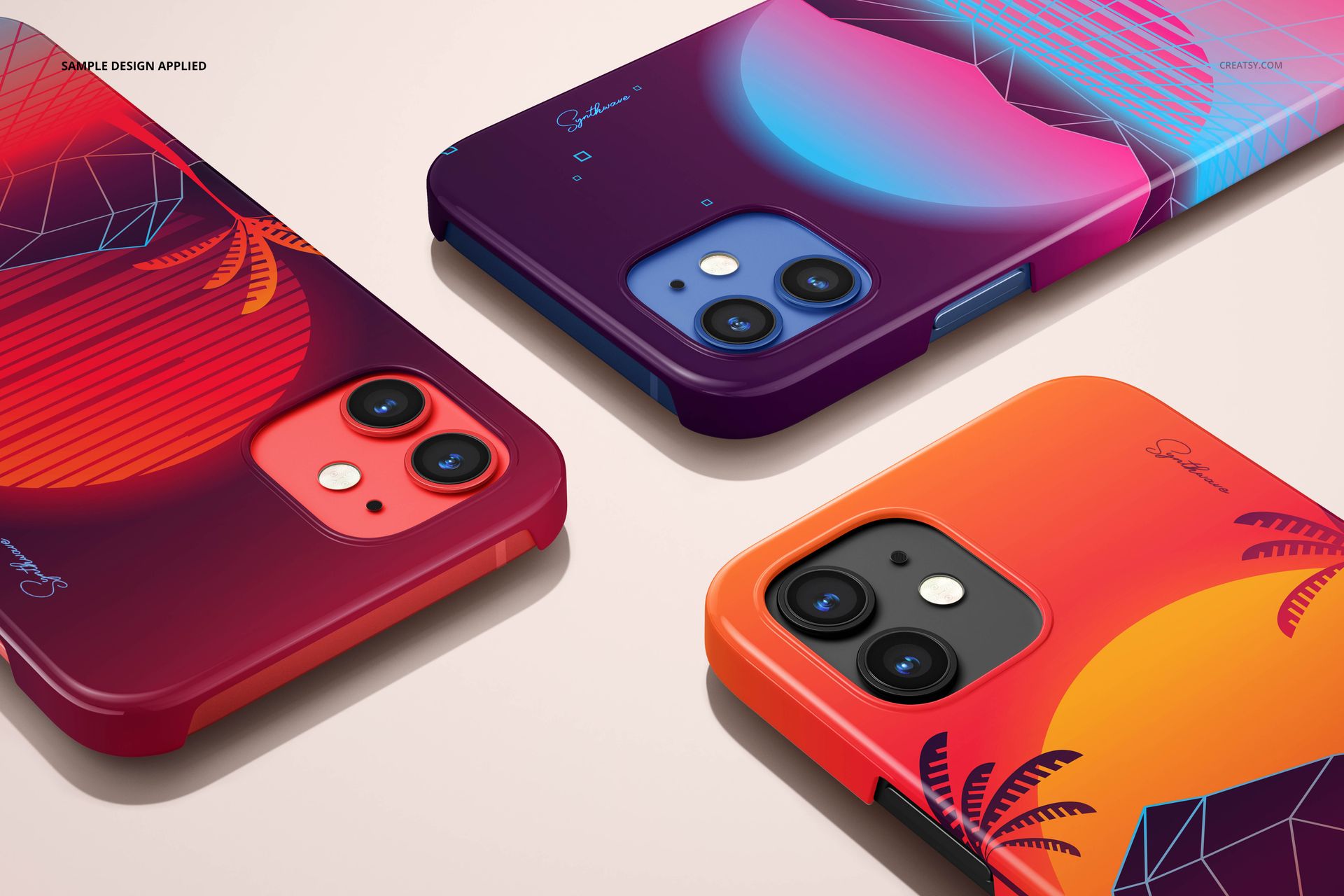 Mockup of iPhone 12 snap cases in red, purple, and orange, each with bold graphic artwork, viewed from above.