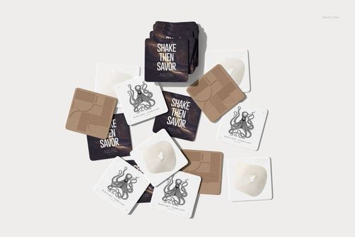 PSD mockup of square drink coasters with different illustrations and colors, shown in a flat lay arrangement.