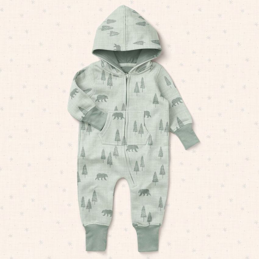 Baby onesie mockup featuring a light green fleece suit with hood, decorated with bear and tree patterns on a pale background.
