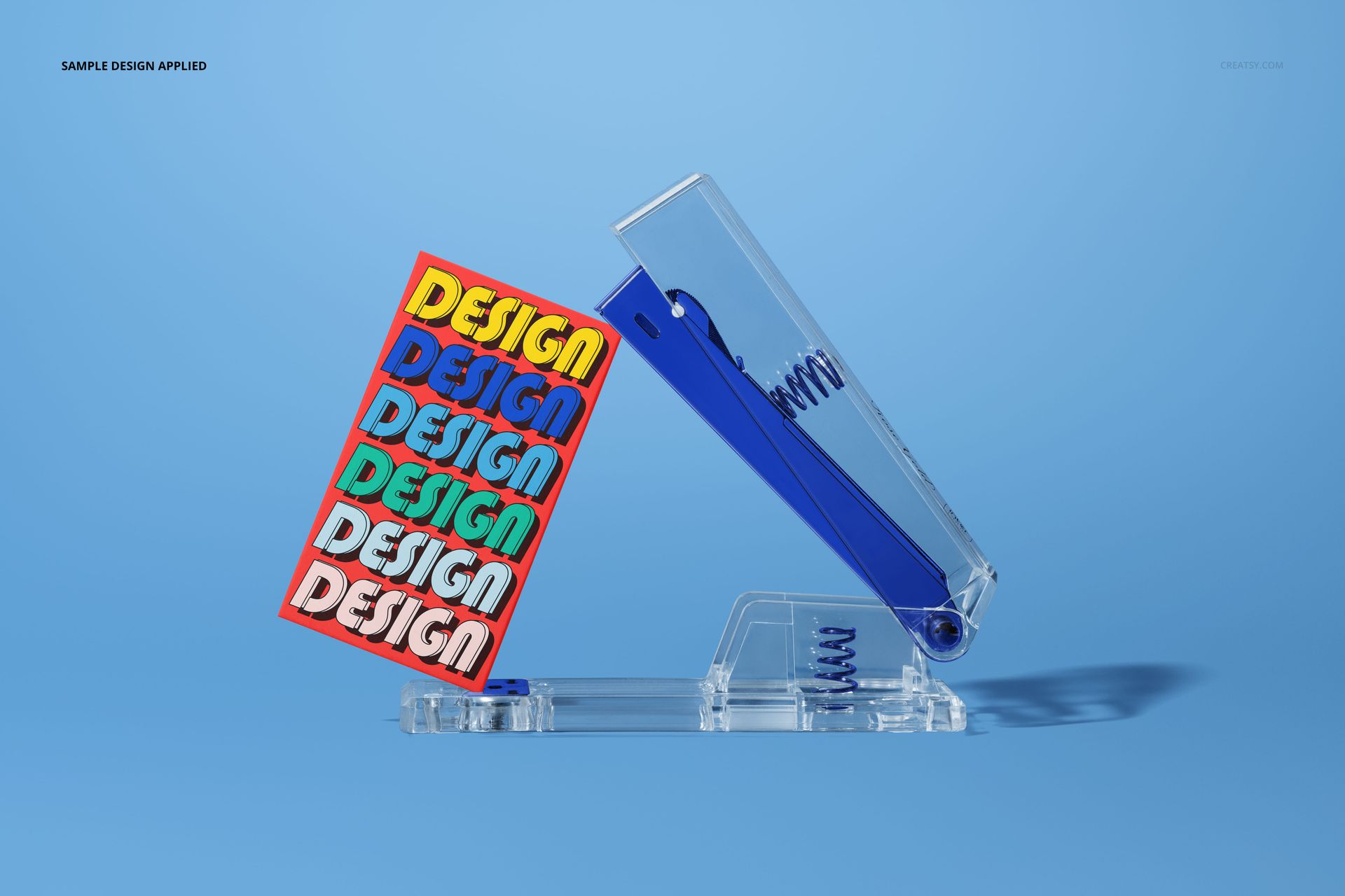 PSD mockup featuring a modern stapler with a multicolored business card, set on a plain blue surface.