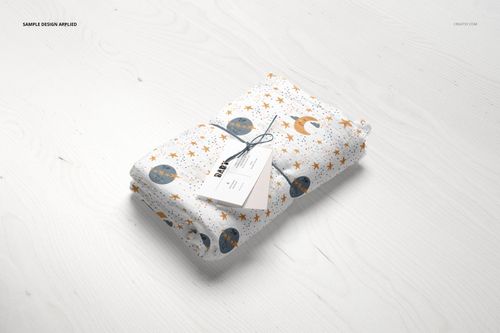 Muslin swaddle blanket mockup featuring moon and star print, folded and tied with twine, top view on pale wood.