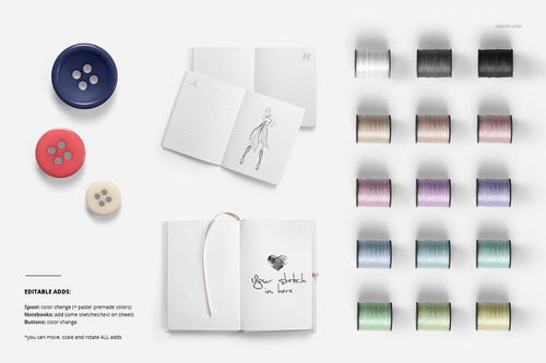 Throw pillow mockup scene with open sketchbooks, assorted colored thread spools, and large buttons on a white background.