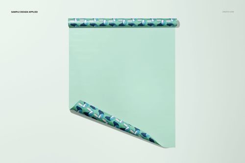 Front view of a single sheet of gift wrapping paper mockup with a mint green surface and folded corner showing geometric blue pattern.