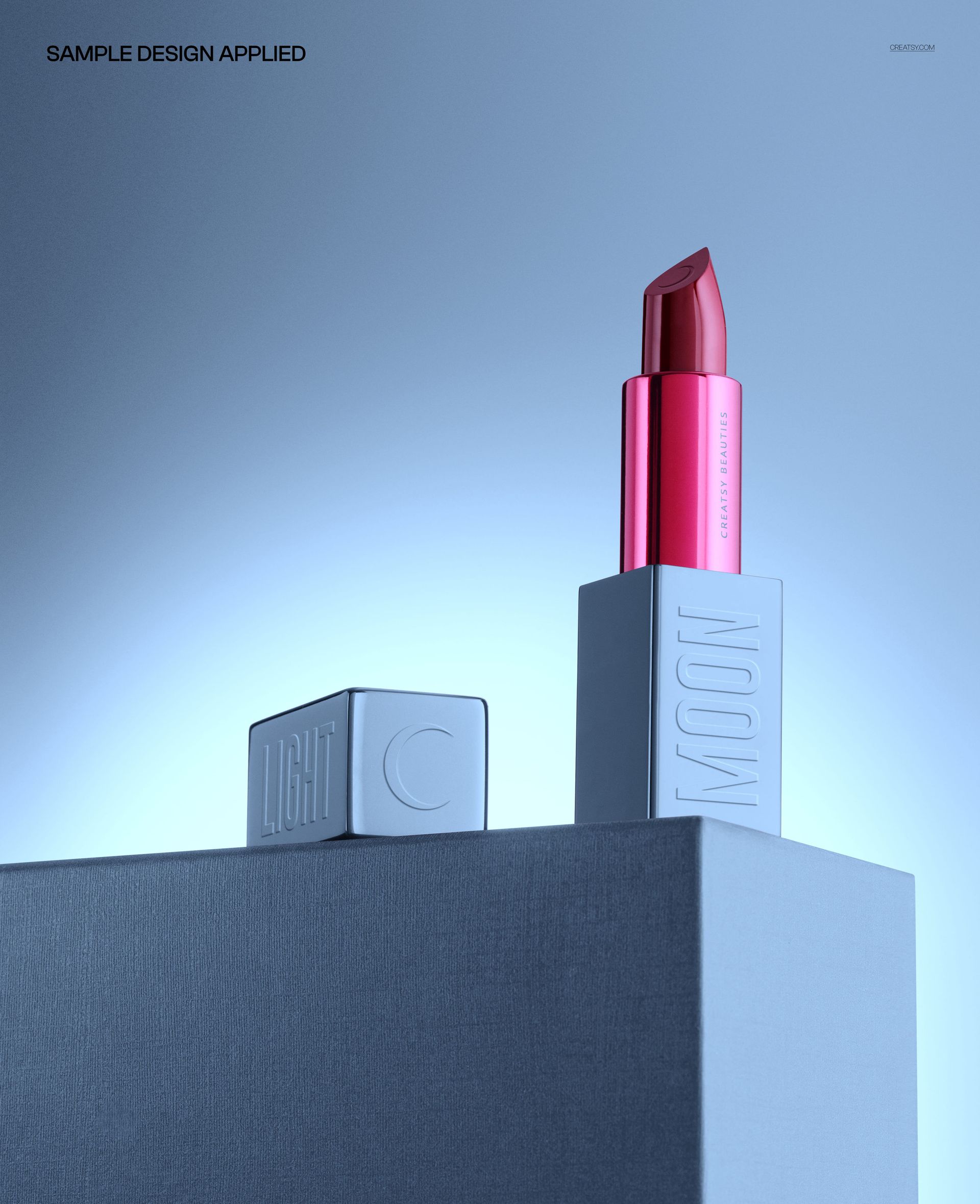 PSD mockup showing a single lipstick on a geometric pedestal with blue gradient background and dramatic lighting.