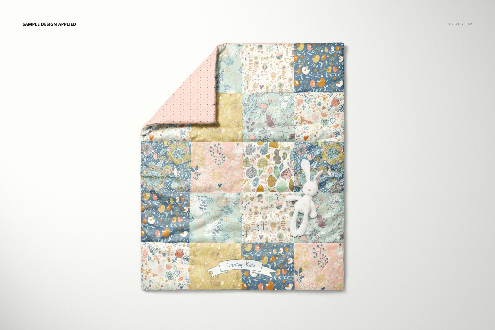 Front view of a baby patchwork quilt with pastel-colored floral and geometric squares, mockup scene on a light background.
