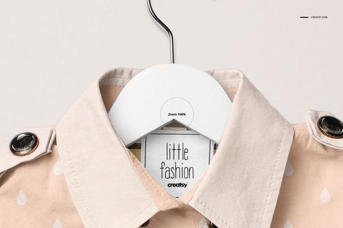 Front view of a baby coat mockup in light peach color with white raindrop pattern, displayed on a hanger against a neutral background.