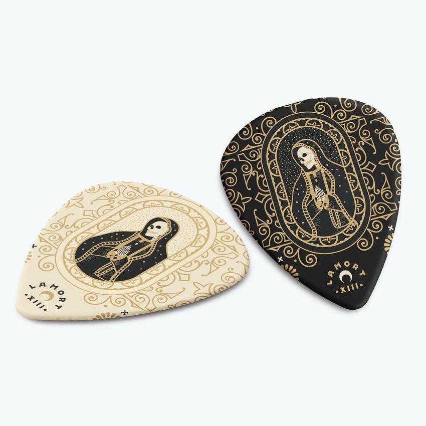 Guitar pick mockup featuring two picks with ornate tattoo-inspired illustrations in black and cream colors on a light background.