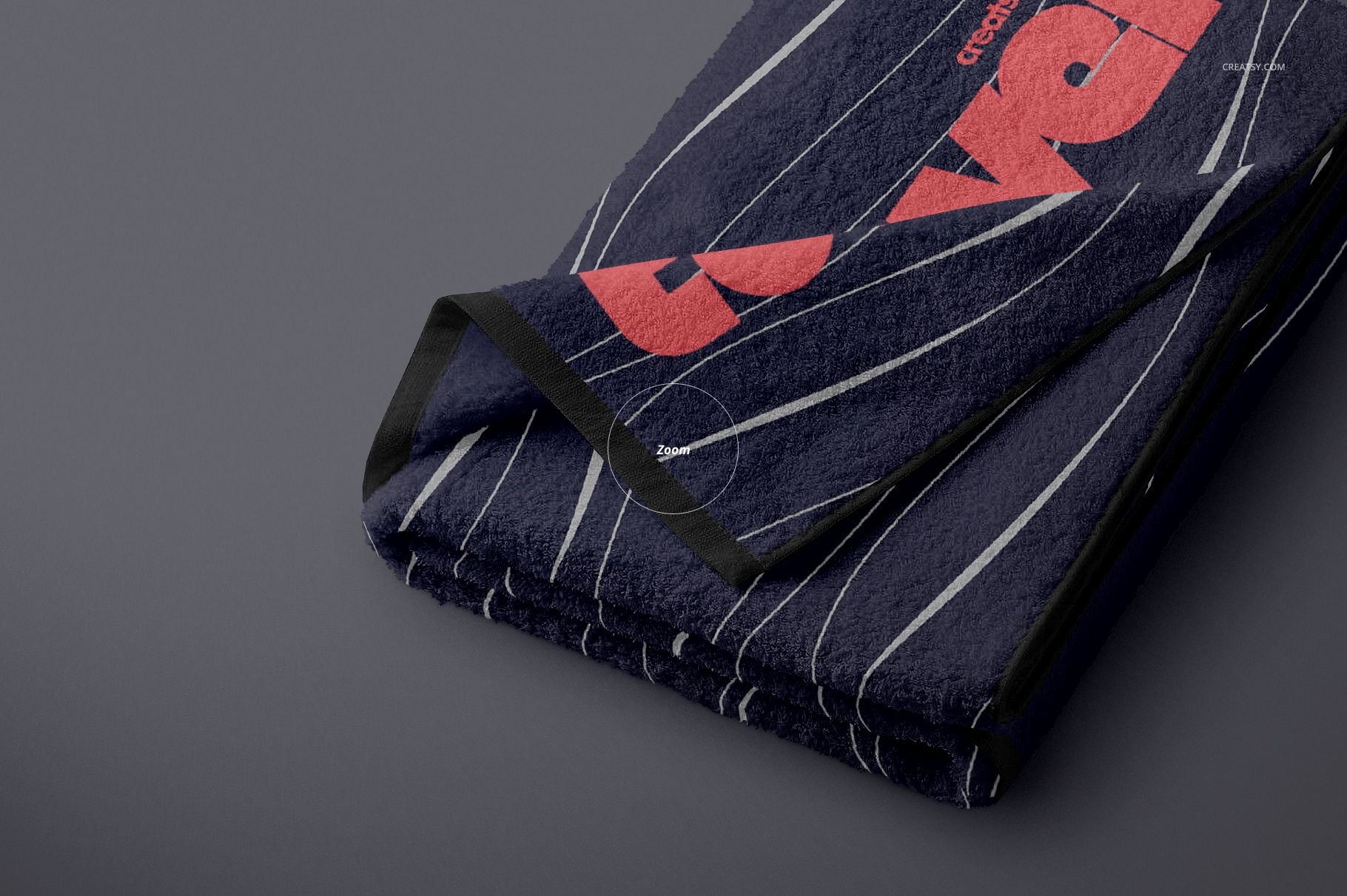 Folded towel mockup with dark blue fabric, thin white stripes, and bold red graphic accents on a gray surface.