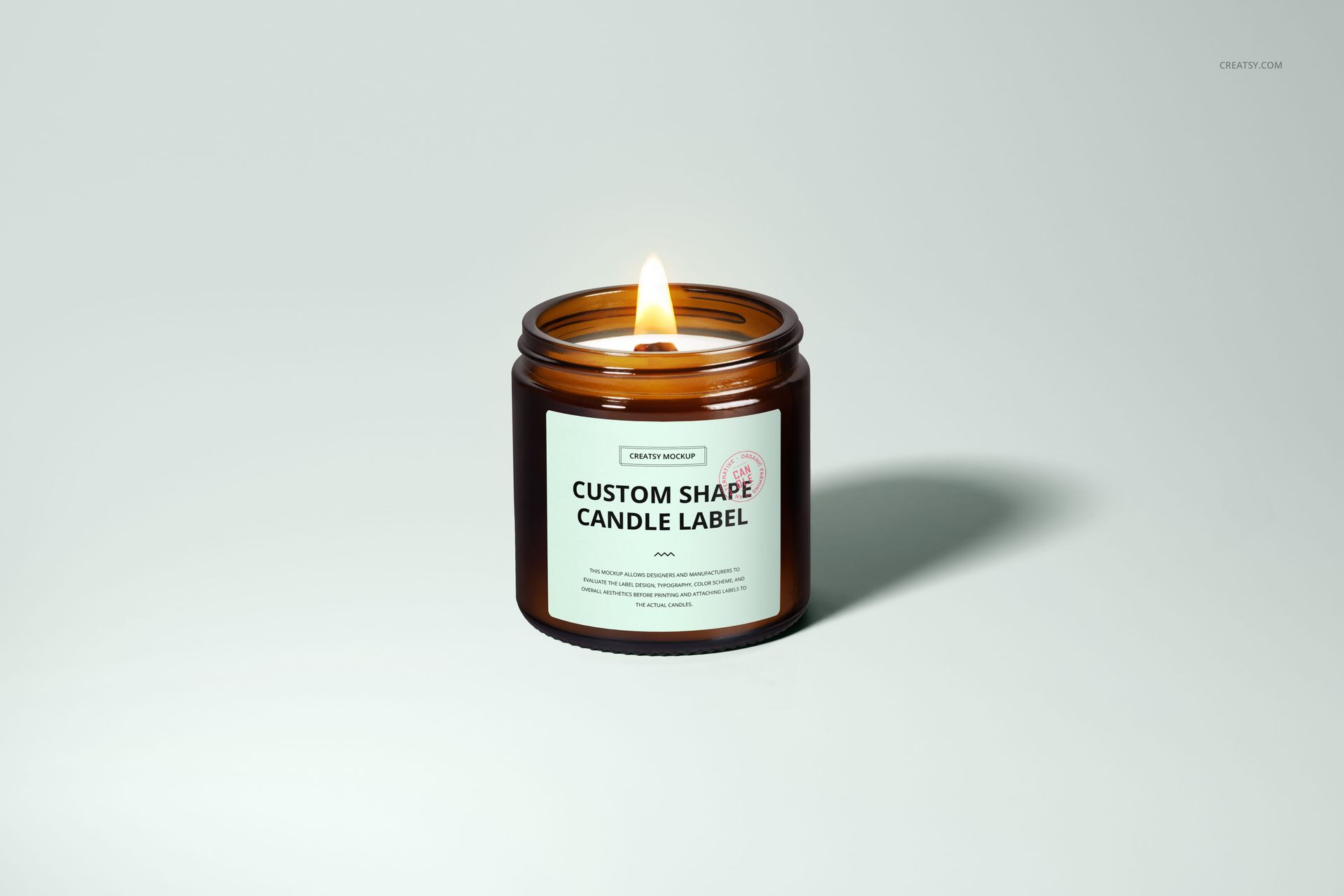 Single amber jar candle mockup with wooden wick, lit and placed on a plain background, front perspective.