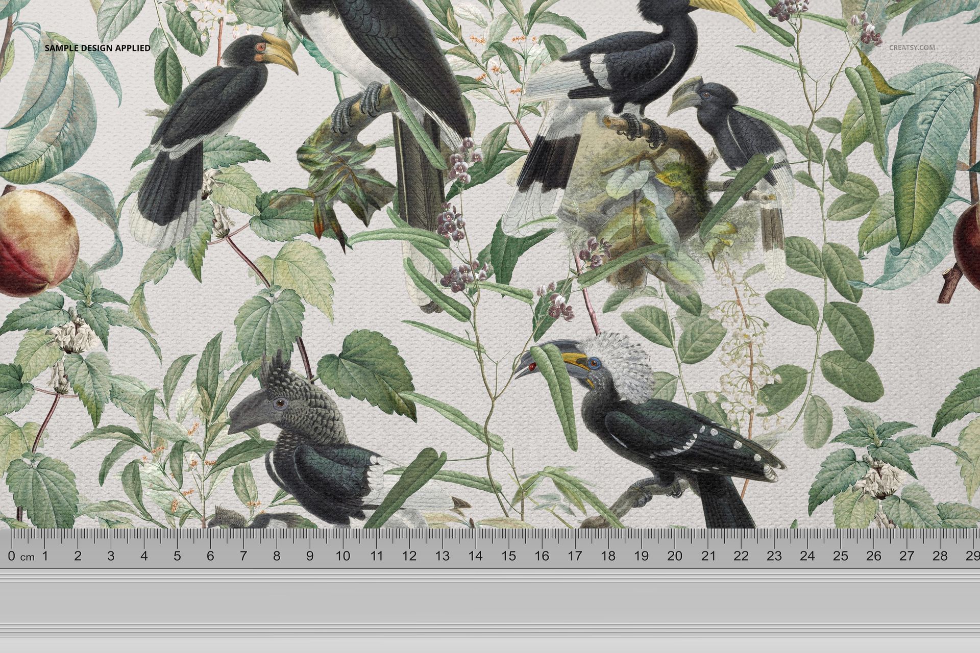 Fabric mockup featuring a botanical pattern with birds and green leaves, displayed with a ruler for scale reference.