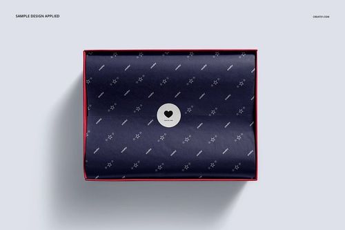 Top view of a shoe box mockup with a navy patterned tissue paper and a round sticker, set against a light gray background.