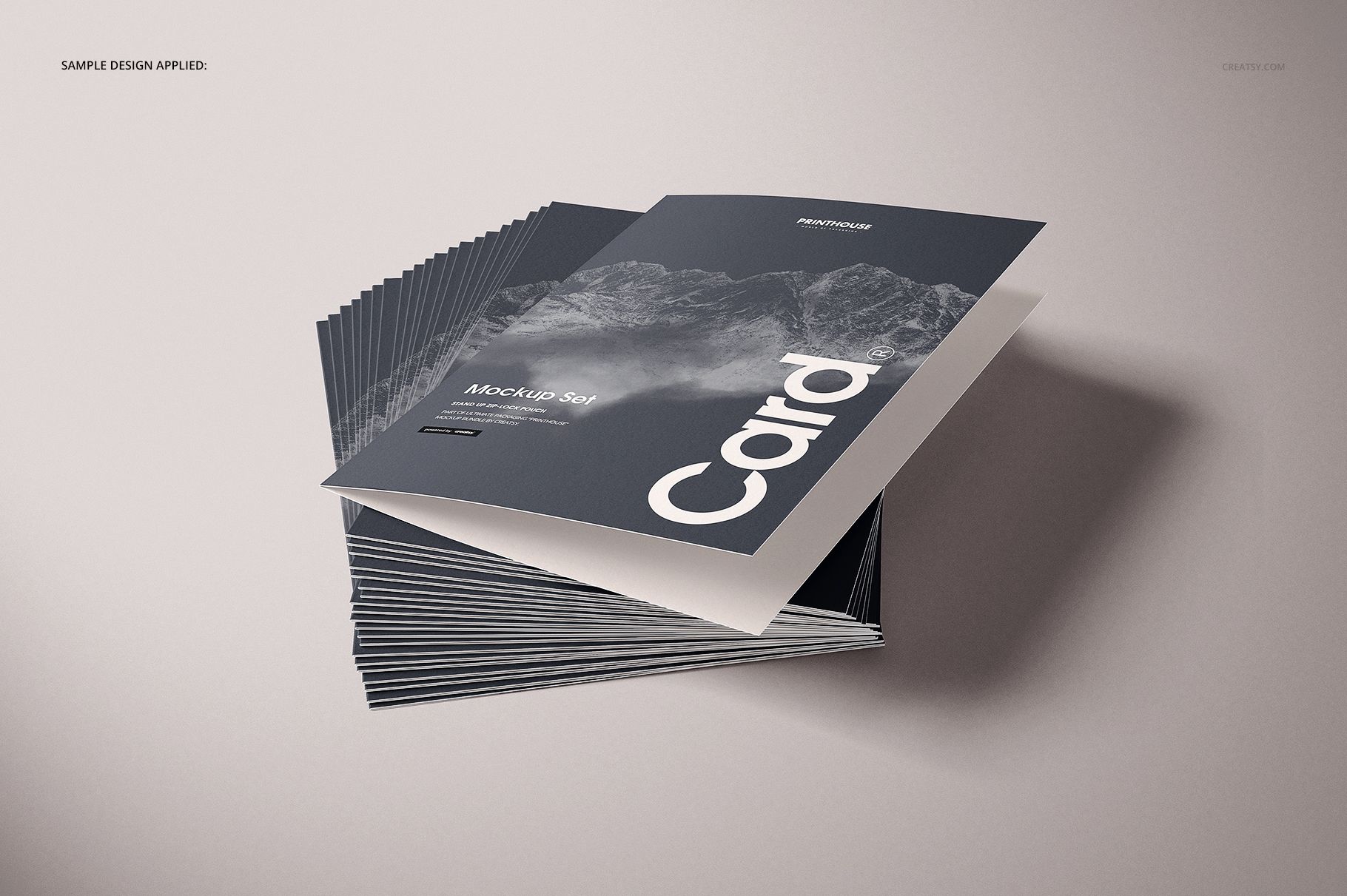 Folded A4 cards arranged in a neat pile, featuring a dark mockup cover with white text and landscape imagery.