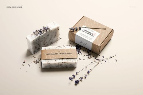 PSD mockup featuring handmade soap bars and a kraft box, each with editable labels, displayed with dried lavender.
