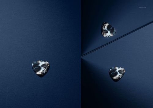 PSD mockup displaying a guitar pick with a bold pattern, positioned on a blue background with dramatic lighting and a mirror.