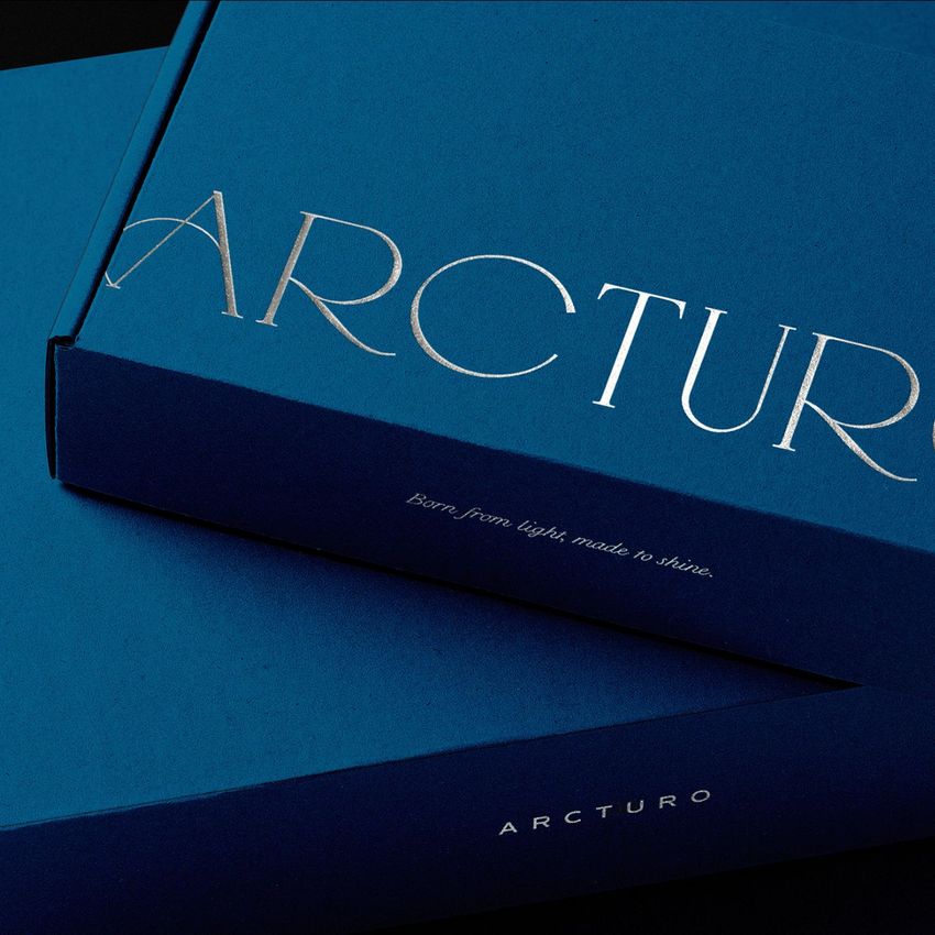 Mailing box mockup featuring two deep blue boxes with silver foil text, shown from an angled top-down perspective on a dark background.