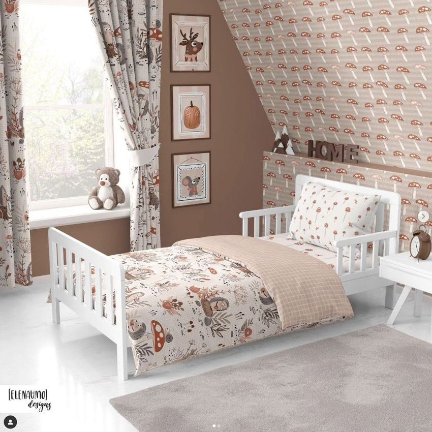 Toddler room bedding mockup showing a white bed with autumn-themed patterned sheets and pillow, set against a brown accent wall.