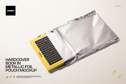 Yellow hardcover book emerging from a shiny silver foil pouch, displayed on a light background, PSD mockup scene.
