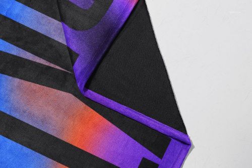 Close-up of a fleece blanket mockup featuring bold black letters over a vibrant blue, purple, and orange gradient pattern.