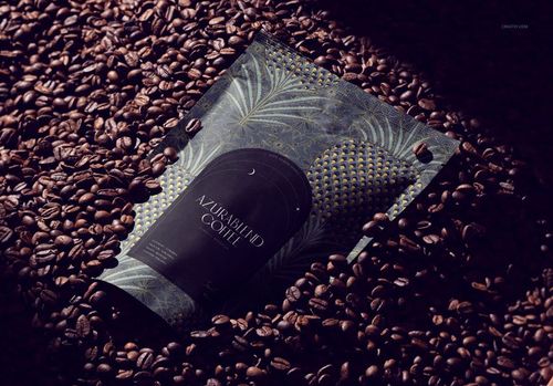 Coffee packaging mockup with a dark botanical pattern, surrounded by roasted coffee beans, shown from a top angle.