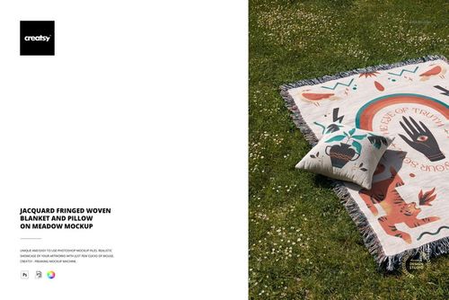 Fringed woven blanket and decorative pillow with geometric design placed outdoors on grass, PSD mockup scene.
