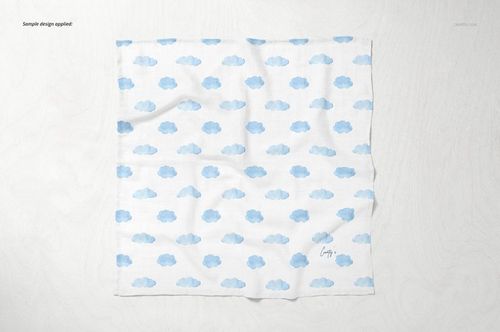 Square baby muslin nappy mockup with a repeating blue cloud pattern, shown from a top view on a light surface.