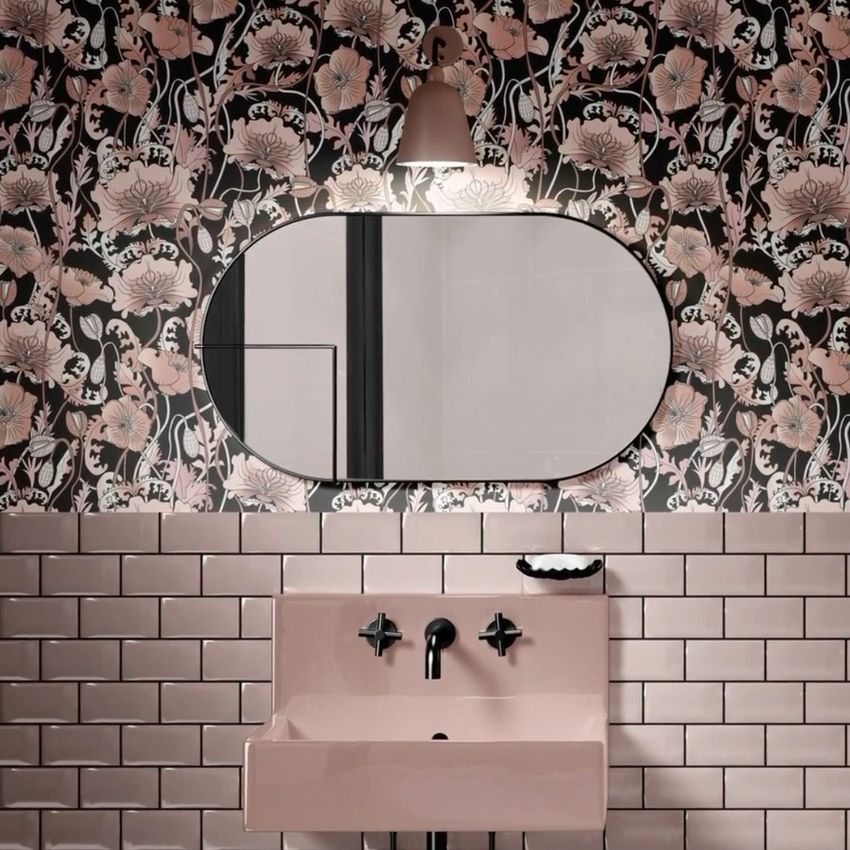 Vintage bathroom mockup showing a pink sink with black fixtures, glossy pink tiles, and floral wallpaper with a large oval mirror.
