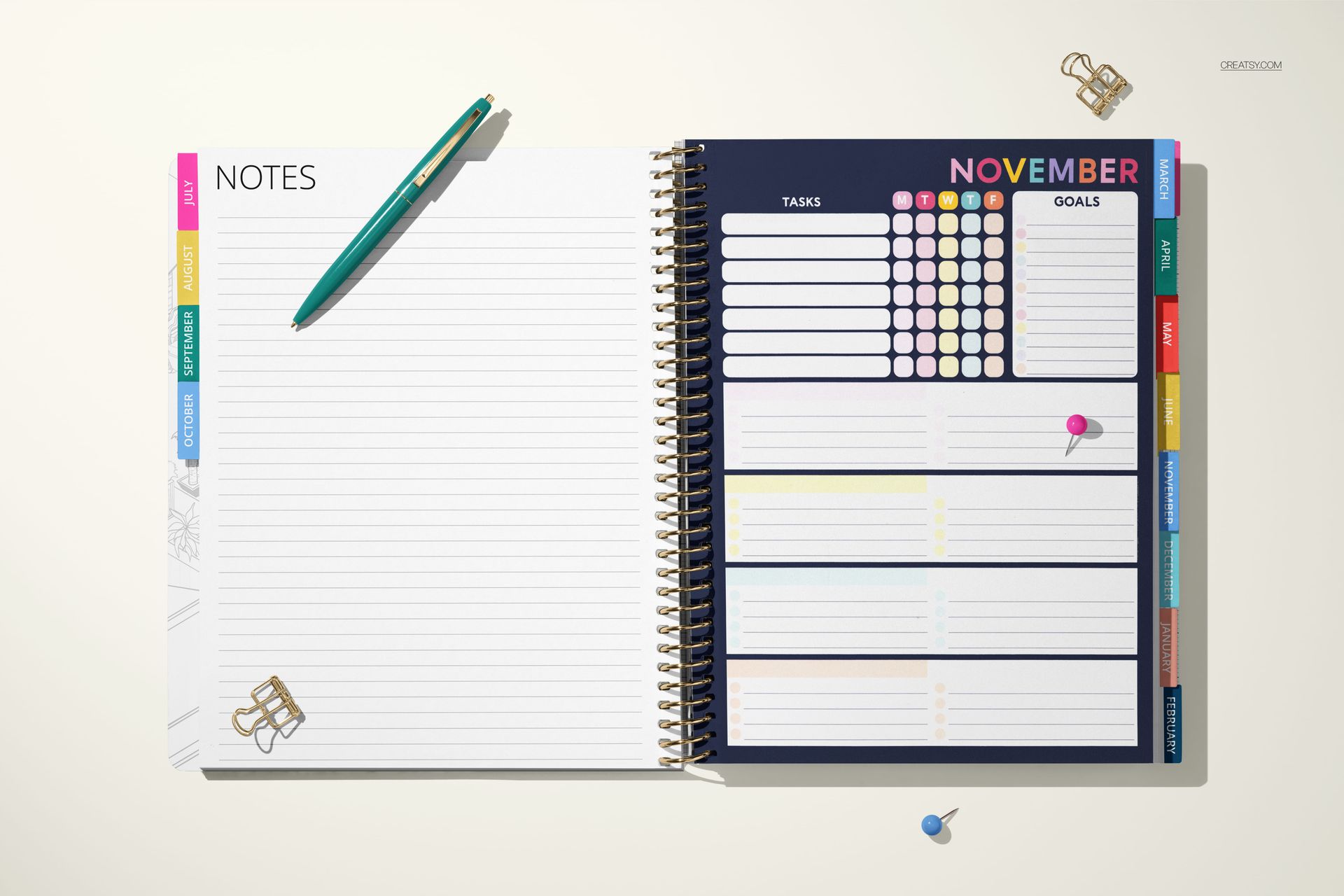 Tabbed stationery planner mockup with organized sections, spiral spine, and vibrant monthly overview in top view.