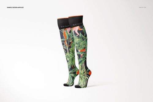 Pair of knee high socks mockup featuring vibrant green foliage and animal illustrations, standing upright.