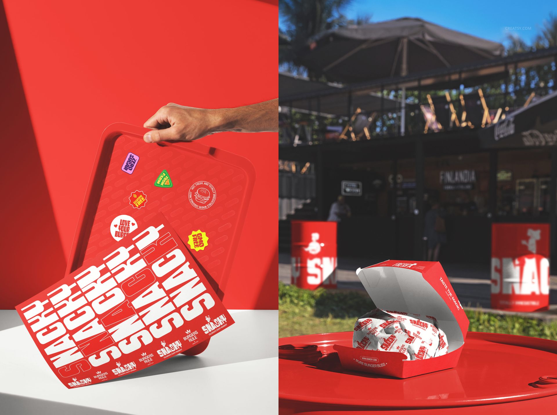 Red fast food tray with bold white lettering and colorful stickers, next to a burger box and wrapper outdoors.