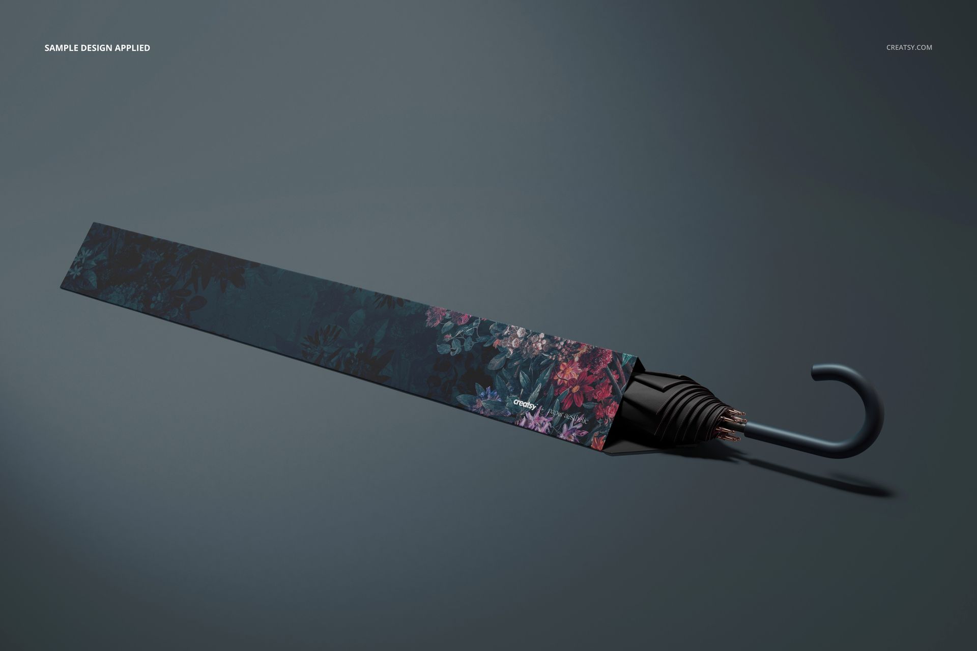 Umbrella packaging mockup featuring a sleek dark floral design, displayed diagonally with the umbrella handle visible.