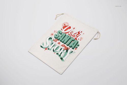 Christmas drawstring sack mockup featuring a cream-colored bag with festive red and green lettering, angled on a white surface.