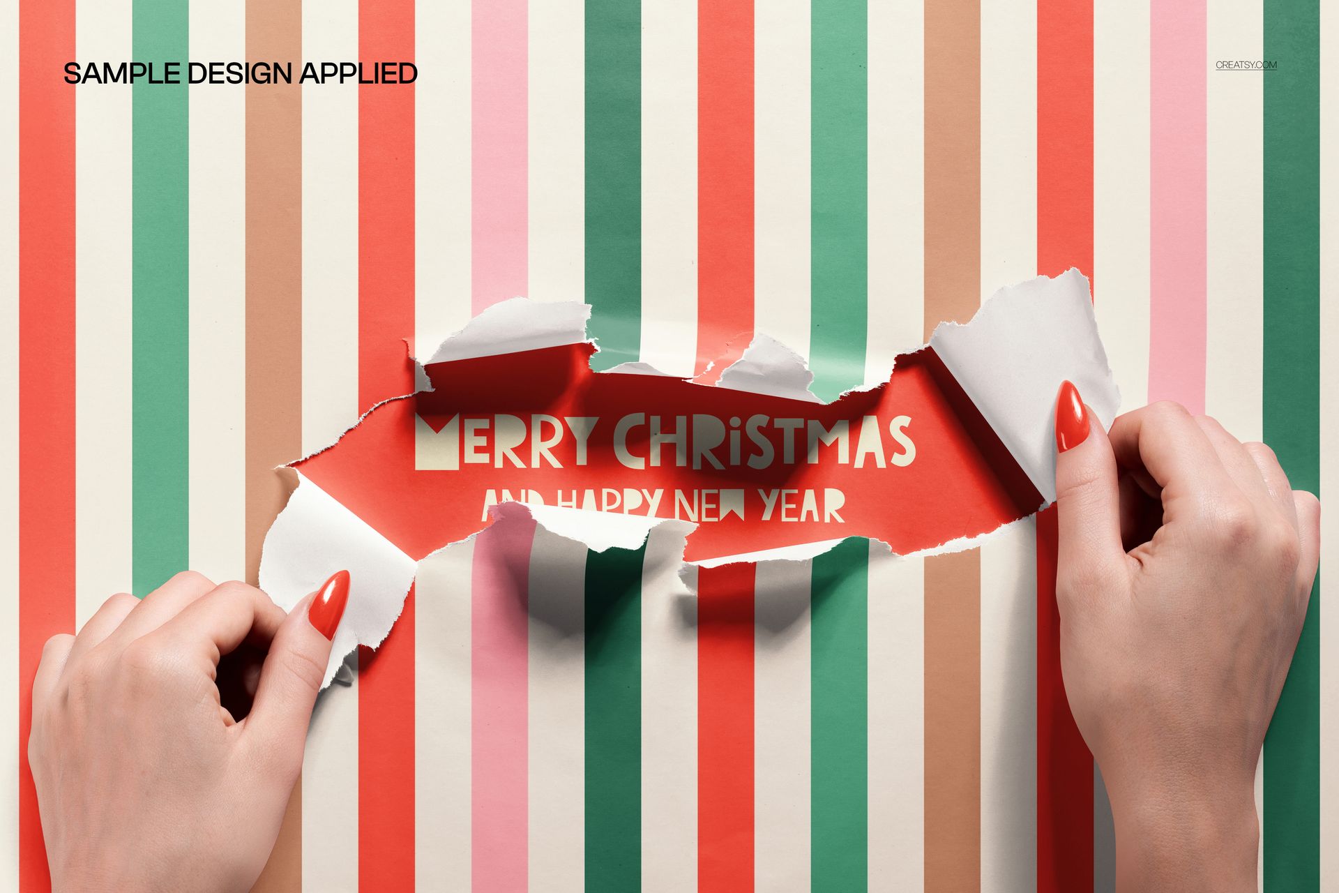 PSD mockup showing hands opening colorful striped wrapping paper with a Merry Christmas message revealed inside.