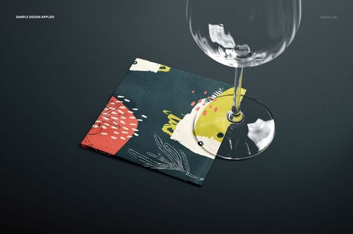Abstract patterned paper napkin mockup shown beneath a transparent wine glass on a smooth dark background.