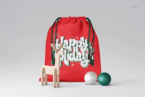 PSD mockup of a Christmas sack in red with green strings, holiday text, and decorative props including a reindeer and ornaments.