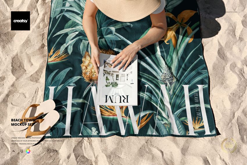 Beach towel mockup featuring a tropical design with pineapples and leaves, shown on sand with a person reading.